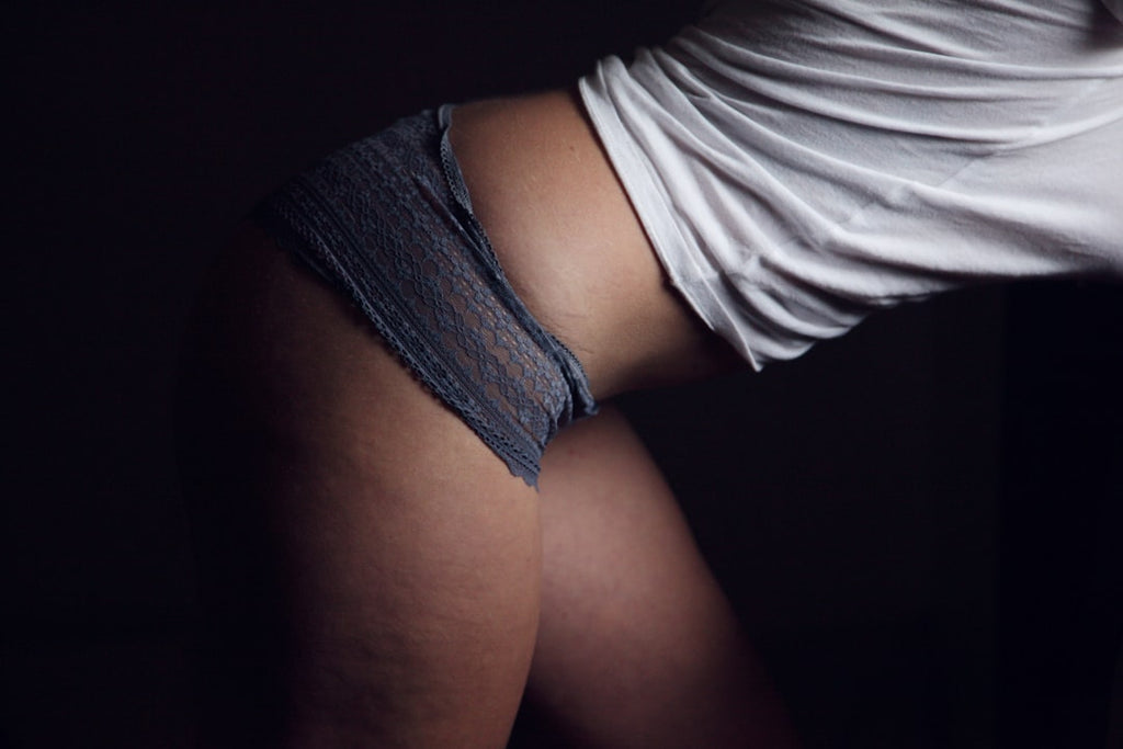 Woman wearing white top with gray culotte femme pants, showcasing stylish women's undergarments.