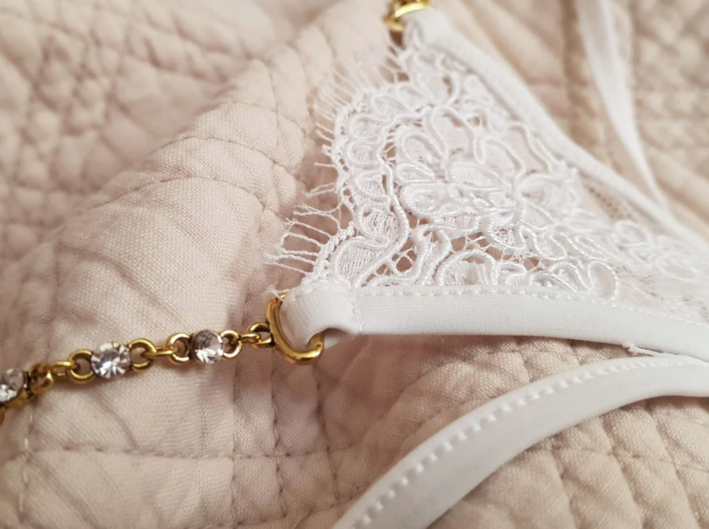 Micro string blanc en dentelle avec chaîne fine ornée de strass, lingerie mini chic et luxueuse pour femme.